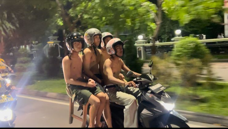 Four people riding together on a motorbike